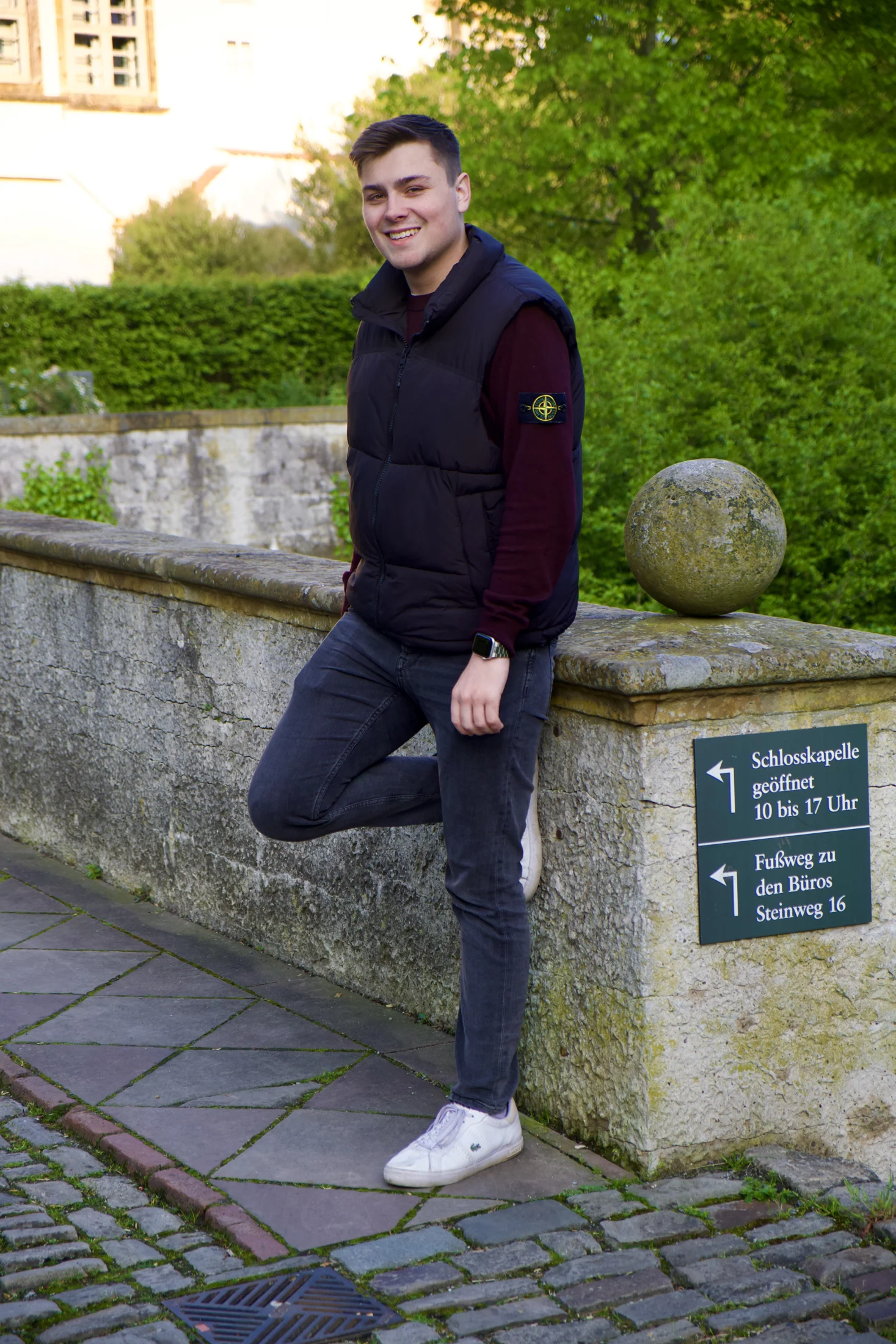 Nick Ritenberg lächelt an einer Steinmauer