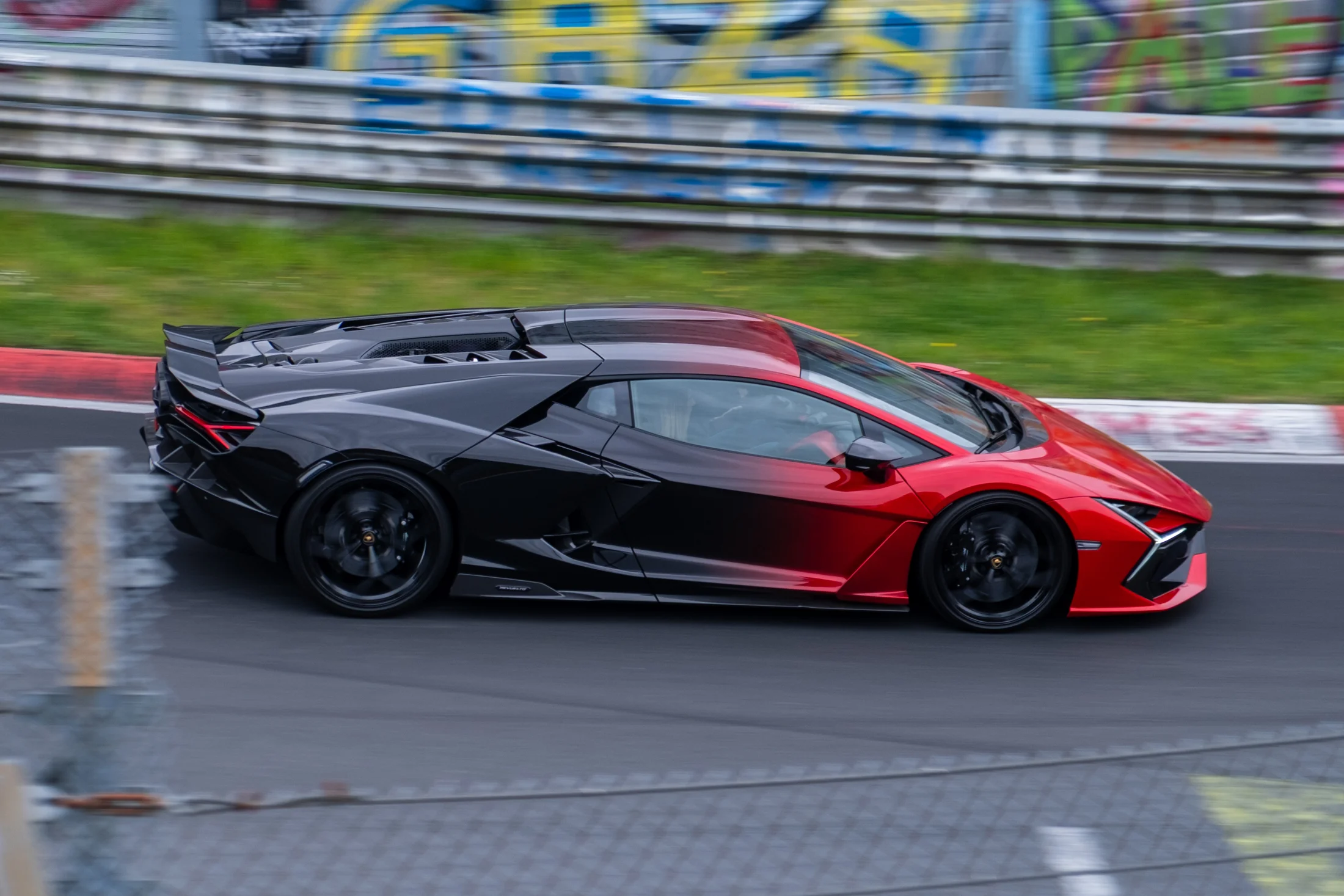 Schwarz-roter Lamborghini in Bewegung auf der Rennstrecke